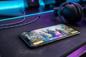 Смартфон с игровым лобби и списком друзей на игровом столе