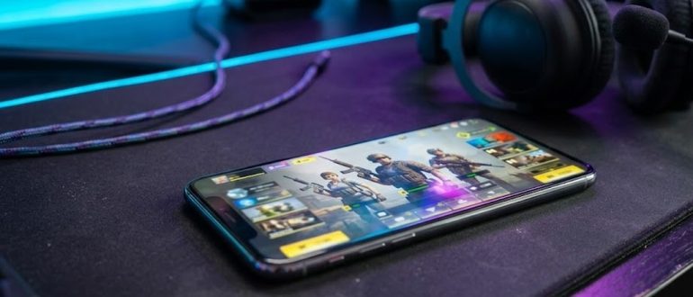 Смартфон с игровым лобби и списком друзей на игровом столе
